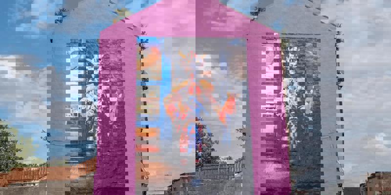 The Rachel Maclean mural of Billy Connolly (The Big Yin) in Viking costume, painted on a bright pink building wall.