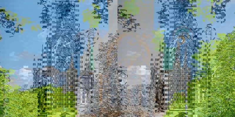 The historic Glasgow Cathedral, a medieval Gothic building, with a statue of David Livingstone in the foreground.