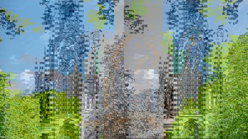 The historic Glasgow Cathedral, a medieval Gothic building, with a statue of David Livingstone in the foreground.