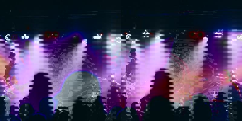 Band performing live at King Tut’s Wah Wah Hut, with dramatic purple lighting and an engaged crowd.