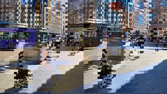 A person in a wheelchair in front of the Duke of Wellington statue outside the Gallery of Modern Art (GoMA) in Glasgow.