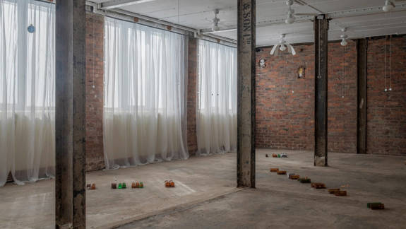 The interior of the David Dale Gallery, an industrial space with brick walls and columns, featuring a minimalist art installation on the concrete floor.
