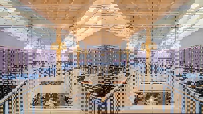 An interior view of Mackintosh at the Willow, a restaurant with a tiered dining area and white and black art deco decor.