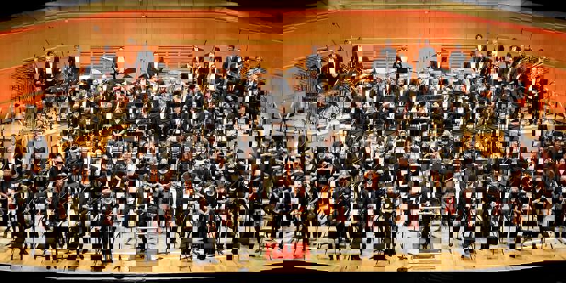 The Royal Scottish National Orchestra on stage at the Glasgow Royal Concert Hall, standing to receive applause. 