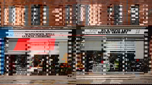 A storefront view of Newlands Home Bakery and Cafe in Glasgow, featuring a red awning and window displays of baked goods.