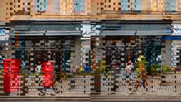 Street view of Kilmurry & Co café with outdoor seating, a bicycle parked at the railings, and a red post box in front