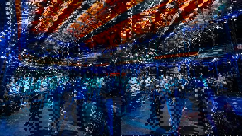 Dancers on the floor of Glasgow’s Old Fruitmarket, lit by string lights under the venue’s distinctive wooden roof.