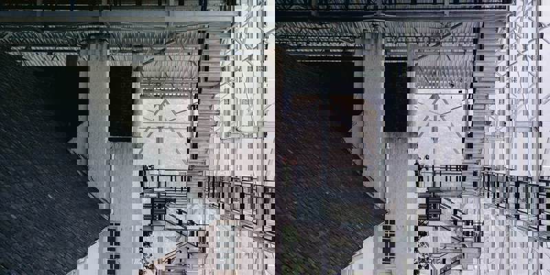 The Hill House, a white historic building, is seen from a unique angle, surrounded by a contemporary glass and steel "box."