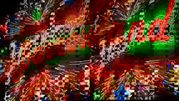 A neon sign for the Barrowland Ballroom with red lettering surrounded by multi-colored stars.