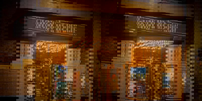 The entrance to the Glasgow Film Theatre, with a lit marquee and a person walking through the doors.