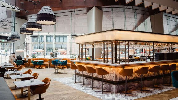 Bright bar with leather seating and large windows.