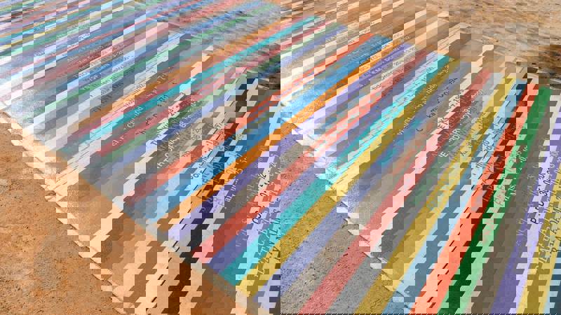 A ground-level artwork with colourful stripes, each labelled with a musician's name and a date.