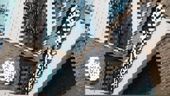 Exterior of The Social Hub Glasgow showing its modern brick and glass façade with large signage above the entrance.